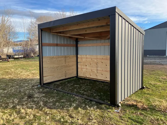 Three-sided gray metal shelter with wooden interior